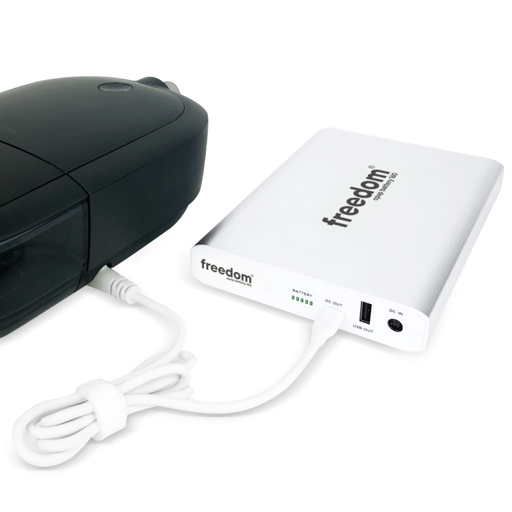 cpaphero Freedom battery pack in white connected to a black CPAP machine via a white power cable.