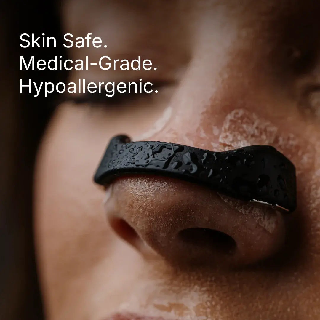 Black Intake nasal strip applied to a person's nose with water droplets on the surface.
