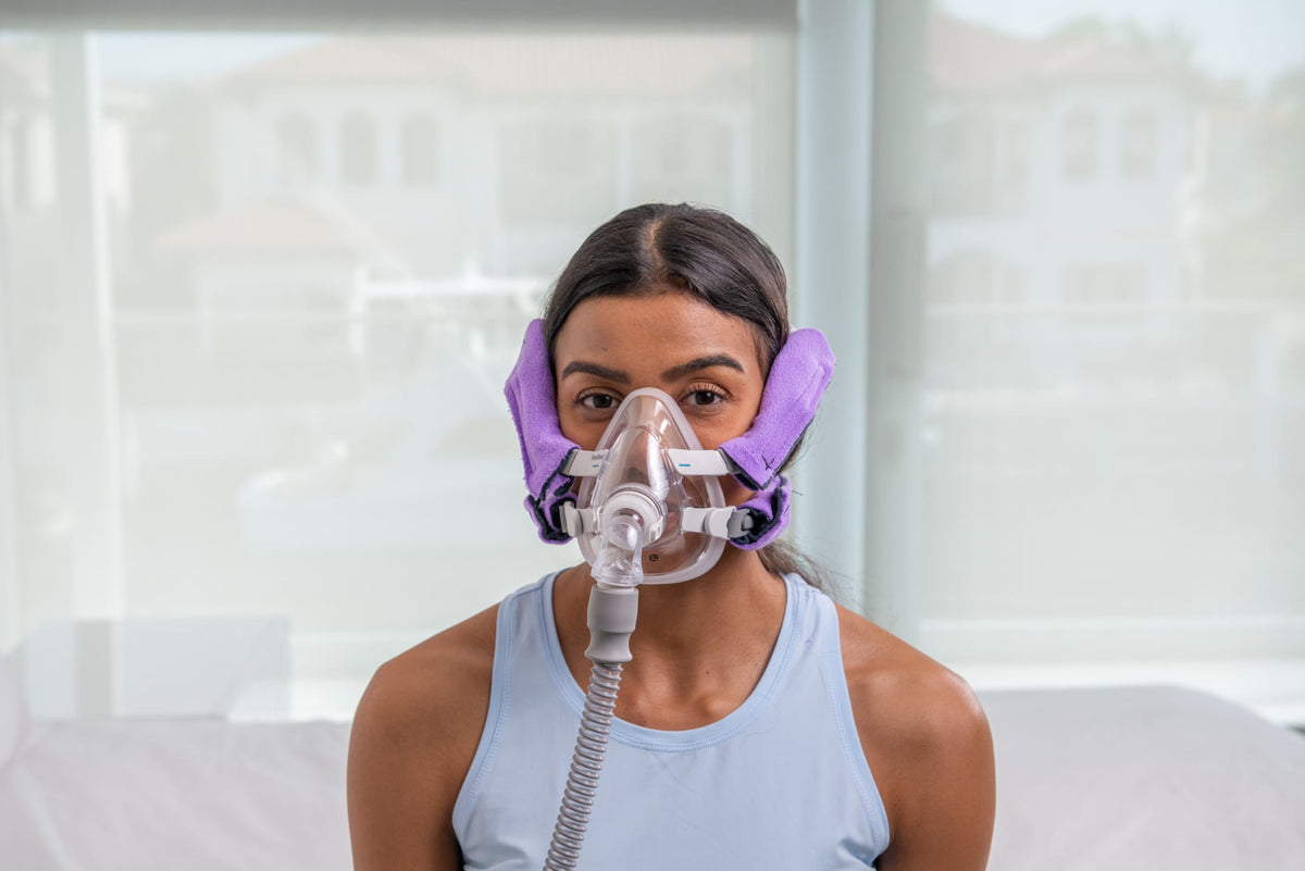 Front view of a woman wearing Snugell CPAPstrapCover in purple, enhancing comfort and reducing strap irritation.