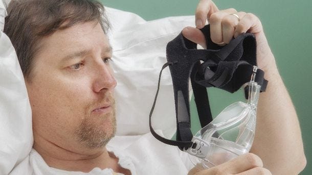 confused man putting on cpap mask