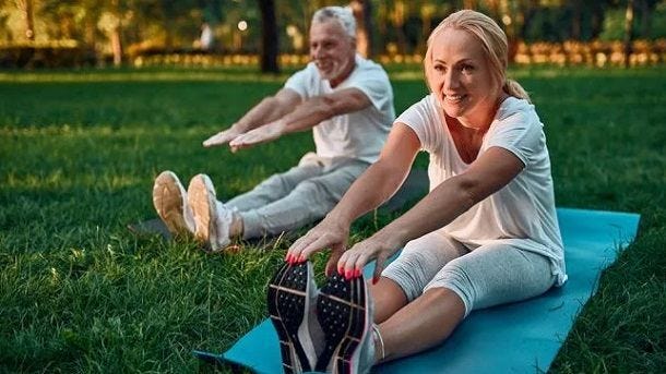 man and woman stretching in park