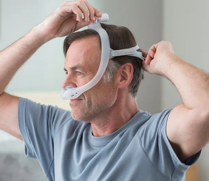 Adjusting a CPAP nasal pillow mask.